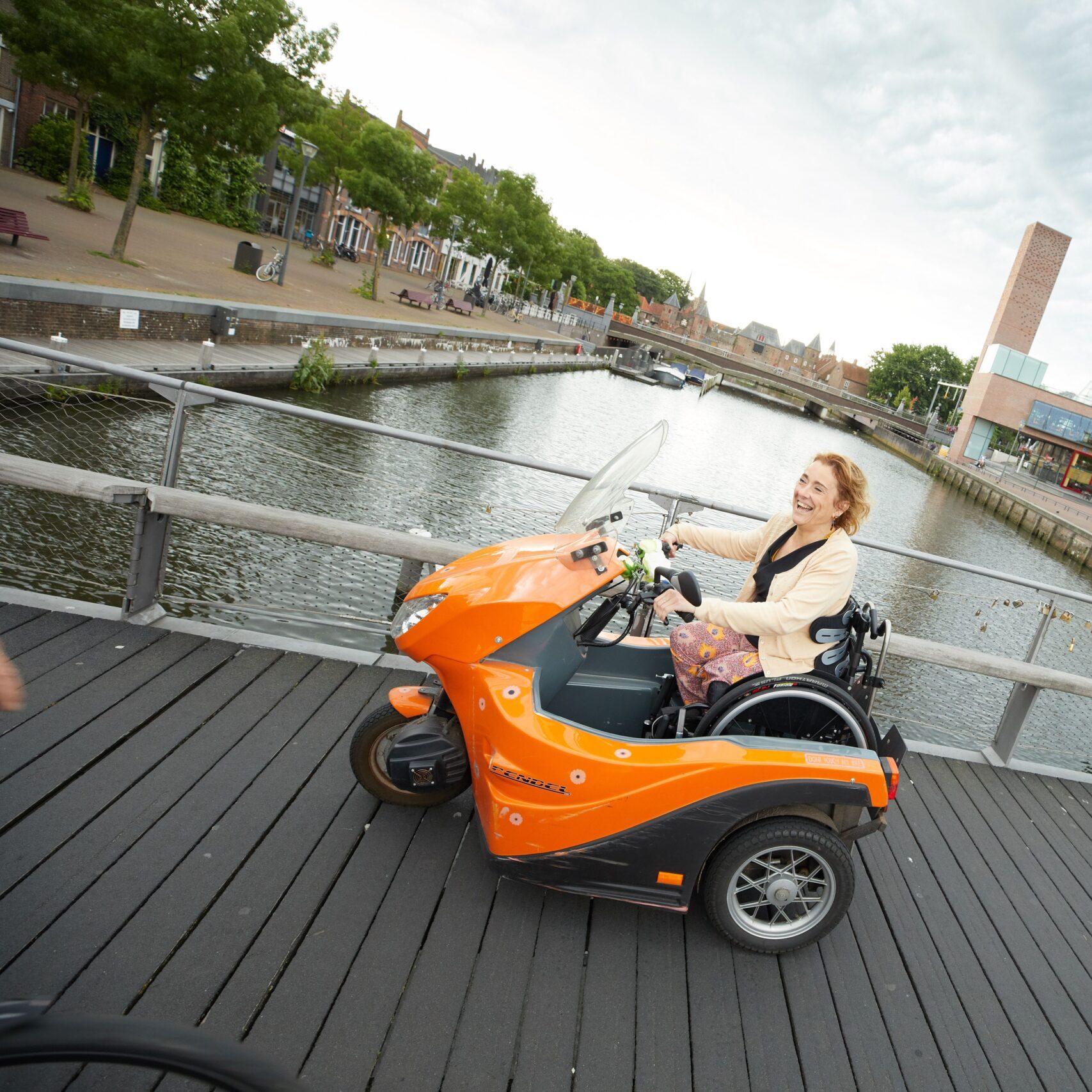 Ingrid op pad in haar oranje rolstoel mobiel. amputatie. rolstoel